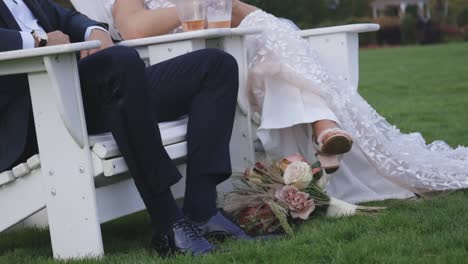 Bride-and-groom-relax-in-beach-chairs-with-their-drinks