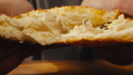 primer plano de alguien comiendo un pan recién horneado