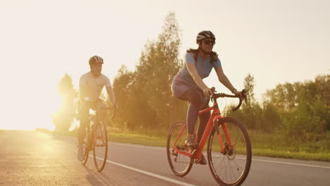 Hard-Training.Triathlete-two-Cyclist-Training-On-Road-Bicycle.-two-Cyclist-Riding-On-Road-Bike-In-City-Park-And-Getting-Ready-For-Triathlon.Fit-Athlete-Intensive-Training-two-man-and-woman-Cycling-Before-Triathlon-Competition.