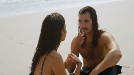 una pareja de surfistas hablando en la playa 4k