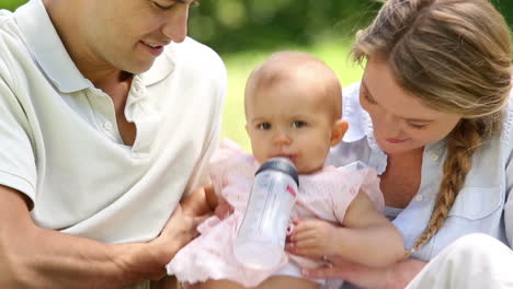 happy parents with their baby girl in the park