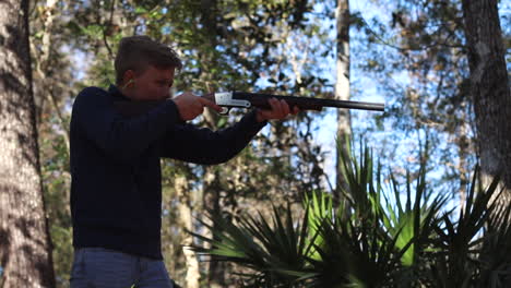 joven apunta arma al blanco