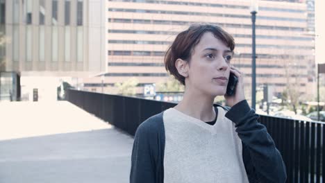 Front-view-of-nervous-woman-walking-and-talking-on-smartphone