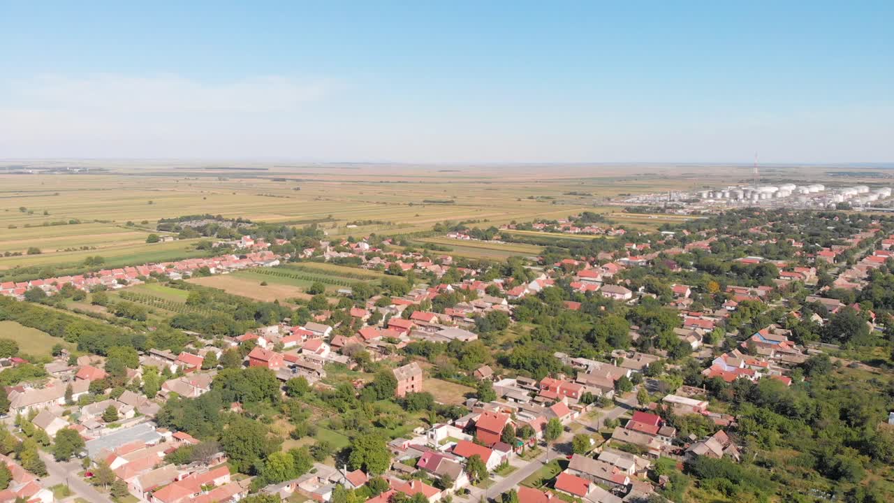 Panoramic Aerial drone footage of village next to oil rafinery. Pollution and health care concept of small towns and villages.
