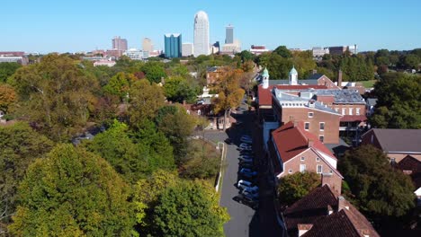 Aerial-Shot-of-Old-Salem-with-Winston-Salem-skyline-in-background