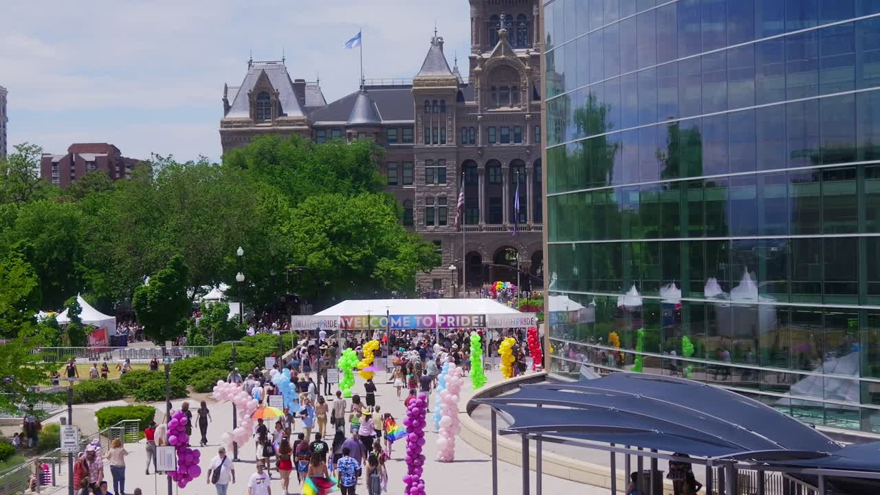 Large Welcome To Utah Pride banner at entrance of event wide shot as camera pans up to the City and County clock tower building