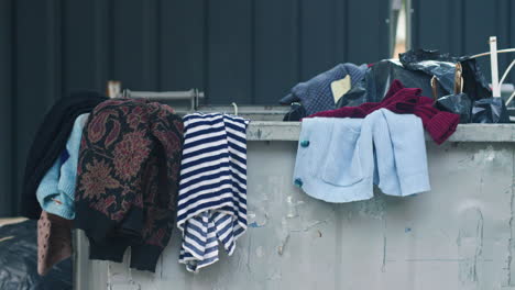 abandoned clothes over, near and inside a dumpster in sofia, bulgaria