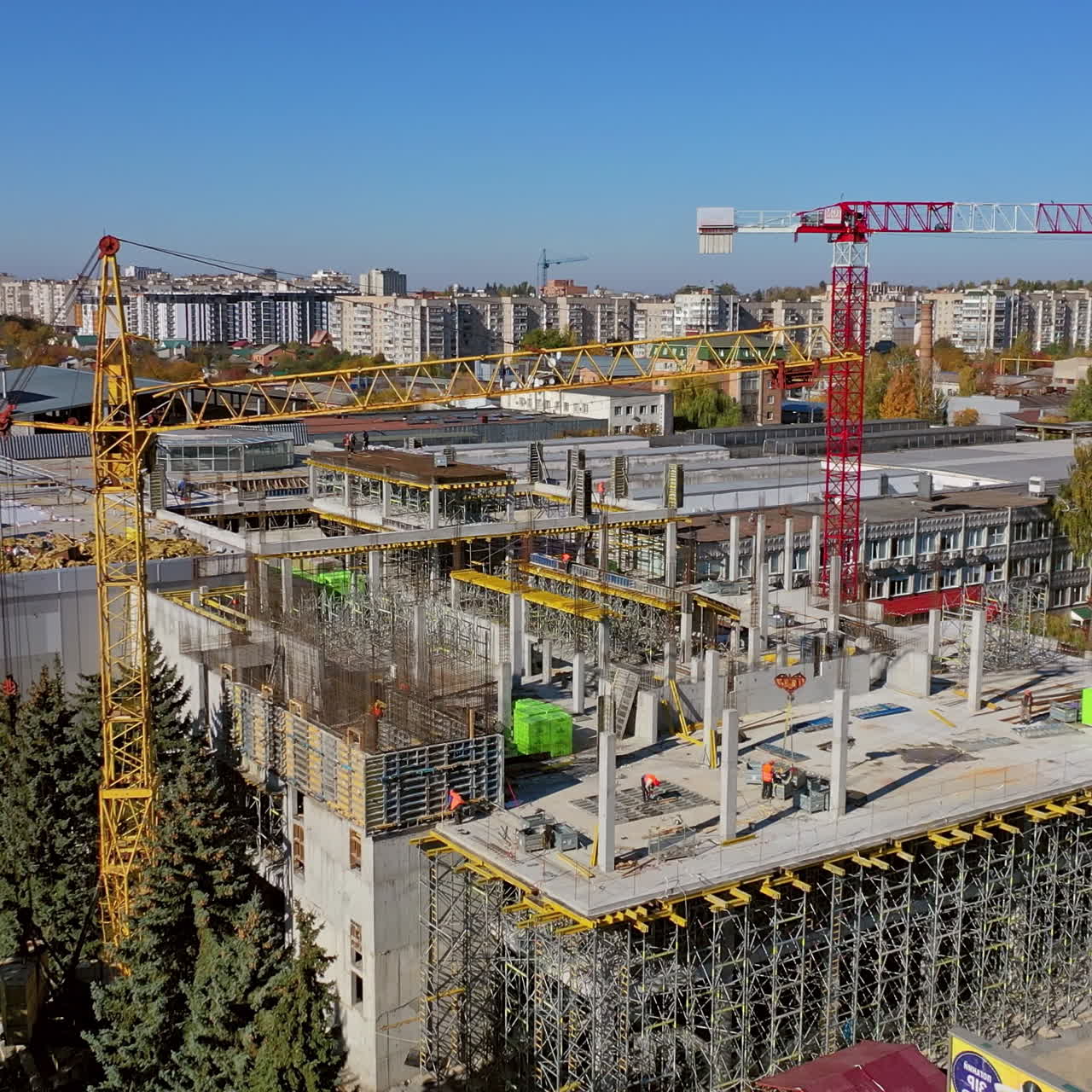 New construction site in the city. Creation of modern residential buildings. Several cranes operate at the site. Aerial view construction site.