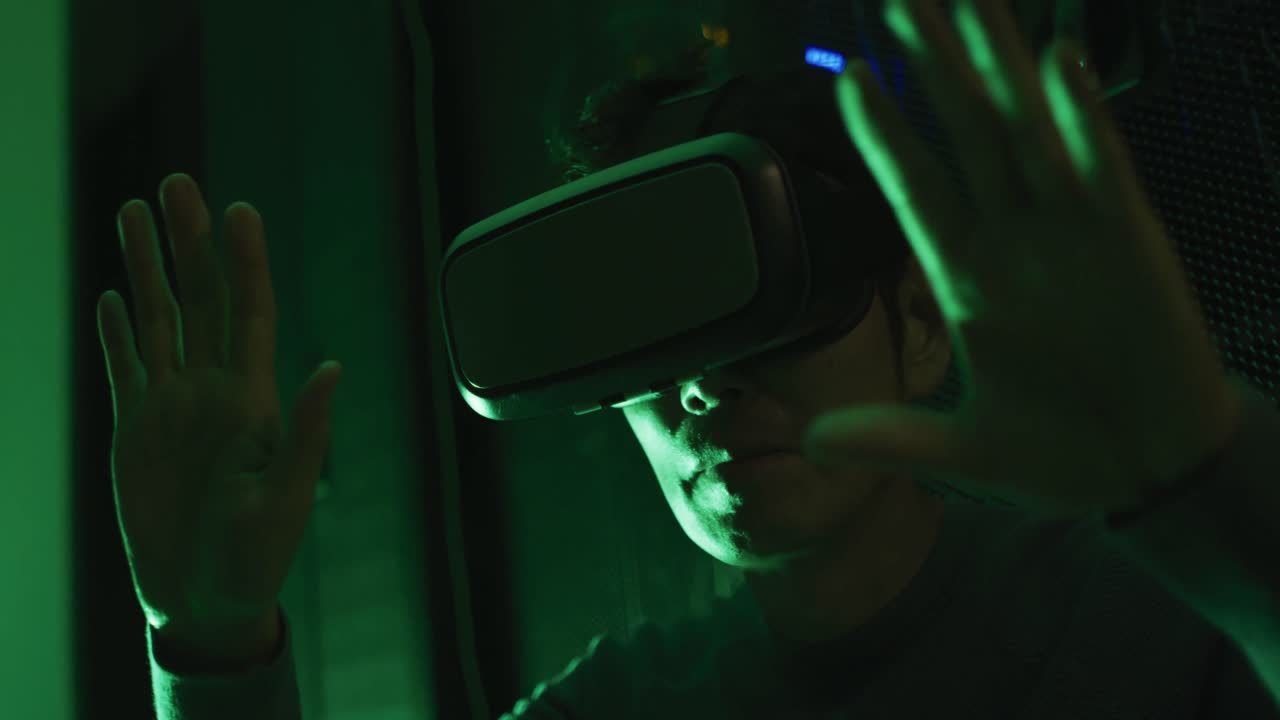 Close up of asian man wearing vr headset by computer servers