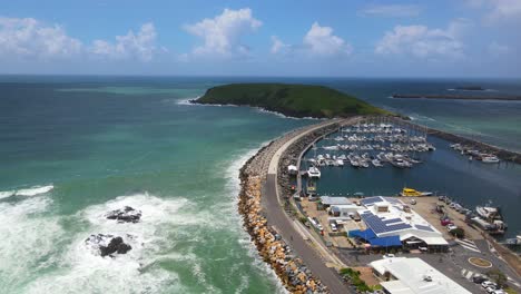 los barcos atracan en el parque marino de las islas solitarias con la reserva natural de la isla muttonbird en el fondo - coffs harbour, nsw, australia