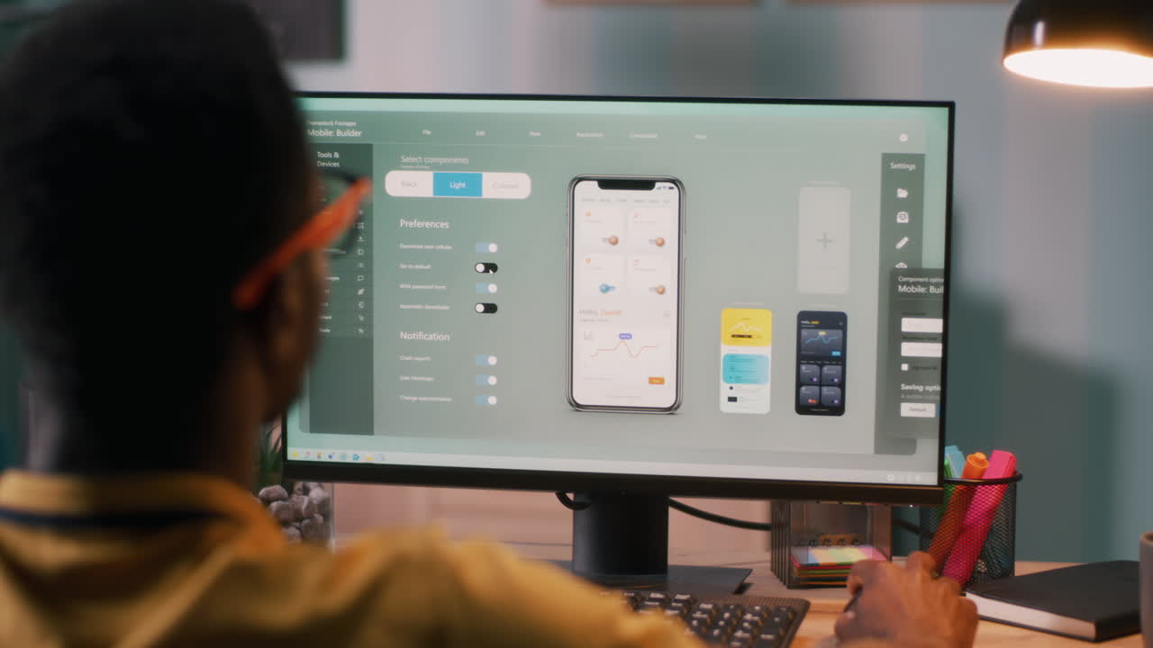 Black Male Creating Cellphone App on Computer