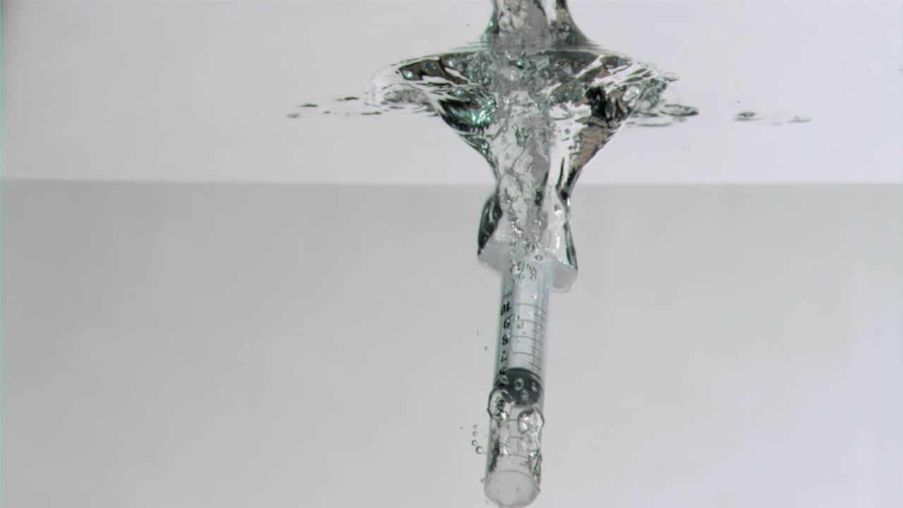 슈퍼 슬로 모션으로 수중으로 떨어지는 주사기