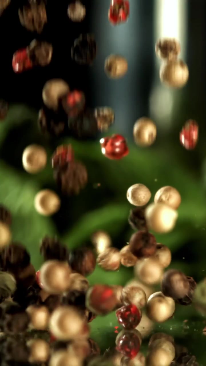 Grani di pepe misti che cadono in super slow motion