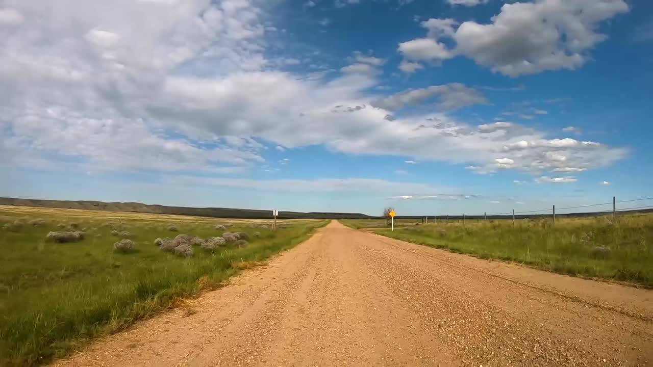 Traveling down a dirt road in the country on a sunny day during the summer.