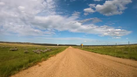 traveling down a dirt road in the country on a sunny day during the summer.