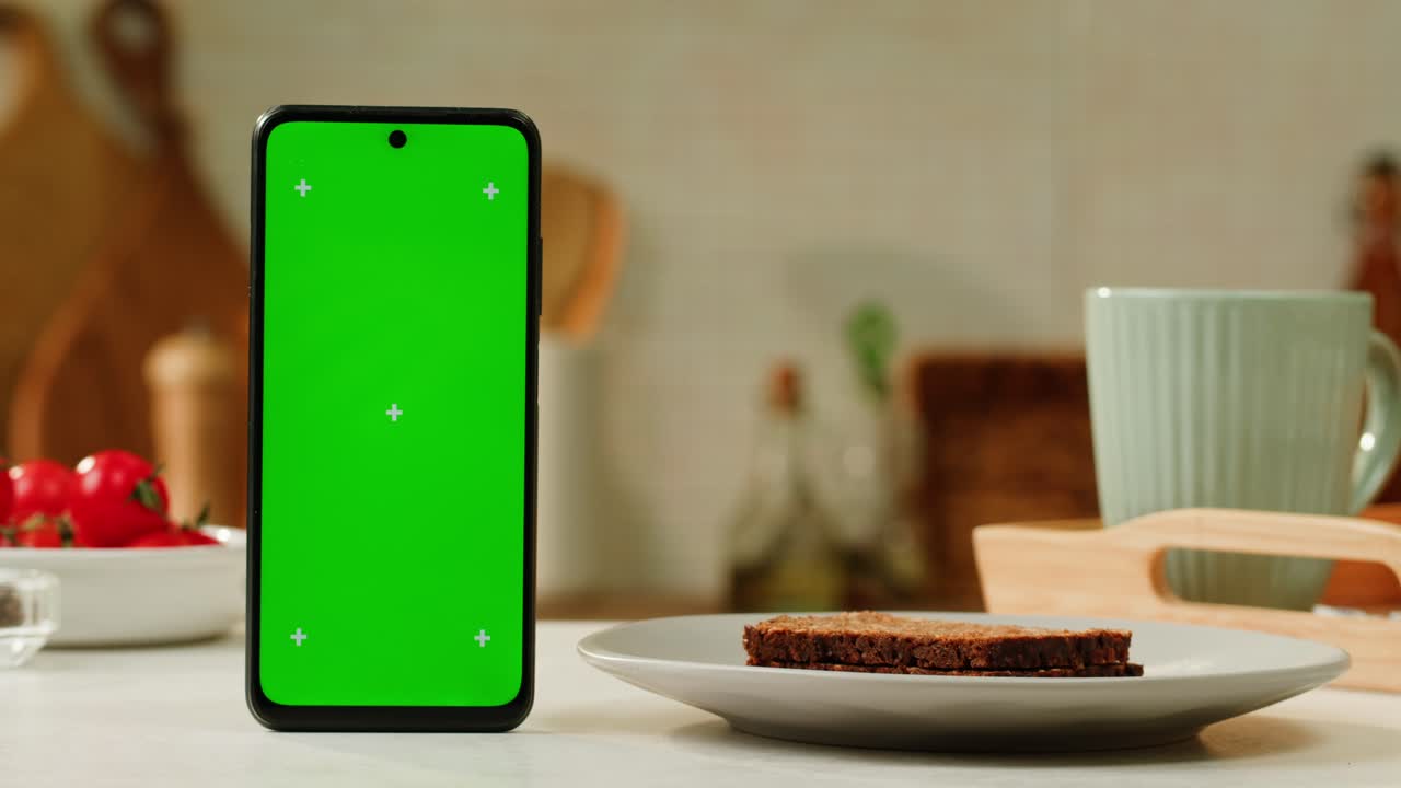 Smartphone with Green Screen on Kitchen Table with Bread