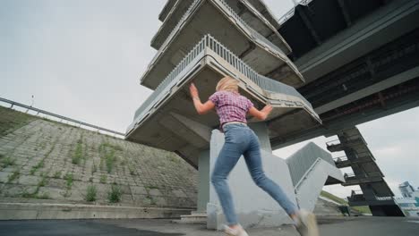woman dancing under a bridge