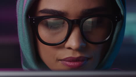 retrato en primer plano hermosa mujer de negocios musulmana usando una tableta trabajando hasta tarde navegando por internet haciendo lluvia de ideas mirando la información en la pantalla usando gafas