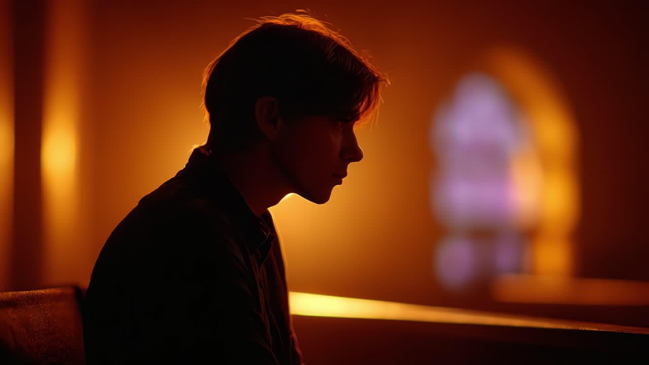 Un momento contemplativo: silhouette di una giovane persona immersa in una luce calda ed eterea in uno spazio tranquillo e sacro