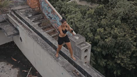 woman practicing martial arts on an abandoned rooftop