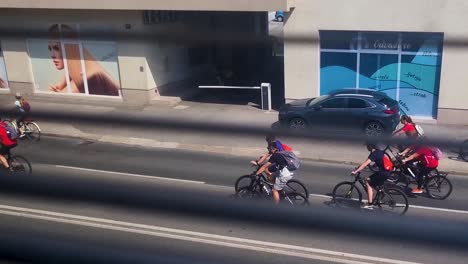 Vista-De-La-Carrera-De-Bicicletas-Desde-La-Ventana-A-Través-Del-Vidrio-De-La-Ventana-Y-Las-Persianas