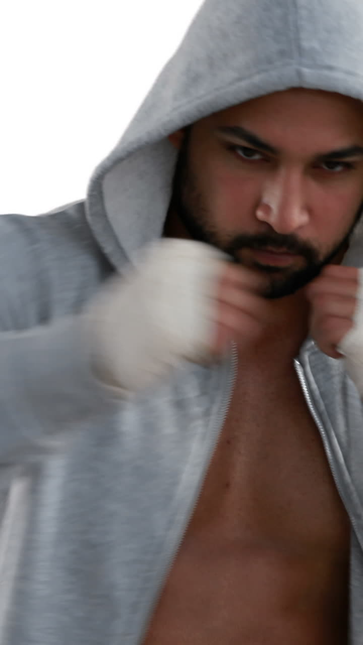 мускулистый мужчина в сером капюшоне