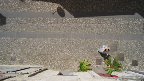 young woman knocking on door tourist holding luggage visiting vacation arriving at destination using smartphone for directions above view