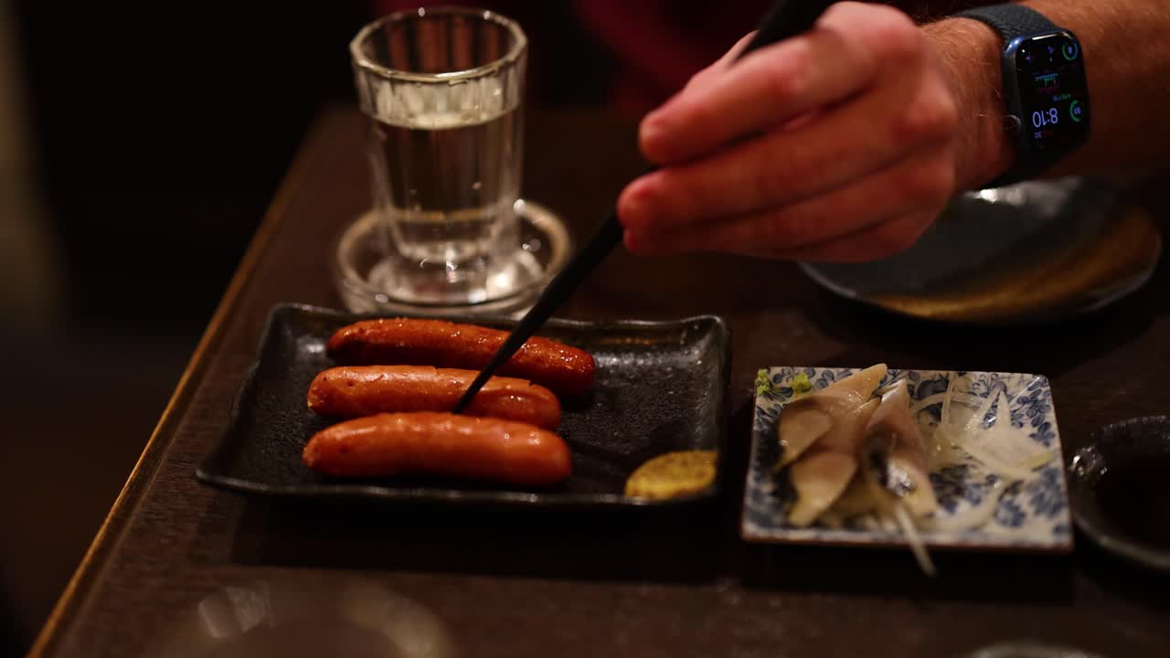 접시 에 소시지 와 사시미 를 제공 하는 사람