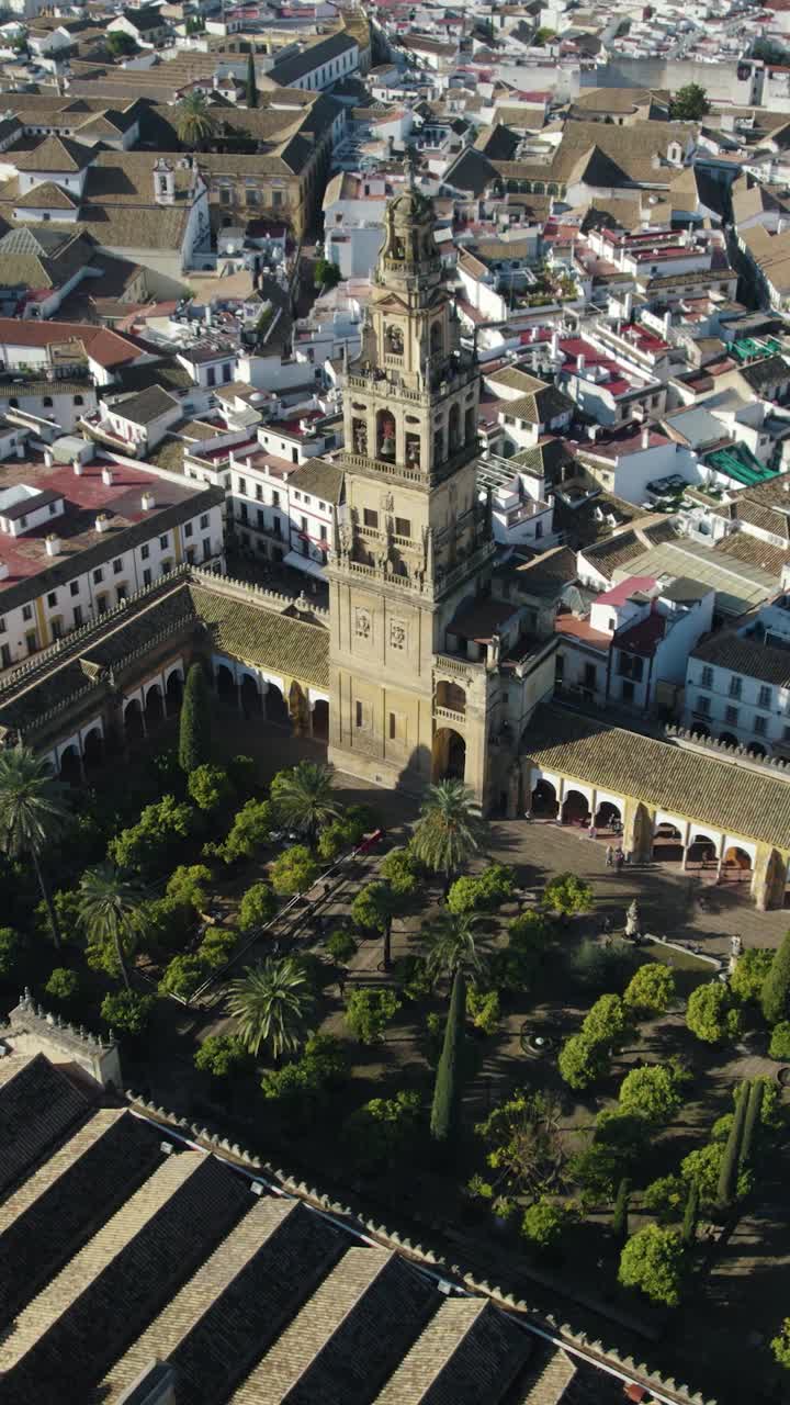 Orbita aerea verticale sopra il Patio de los Naranjos, che circonda l'iconico cortile e la torre campanaria Torre del Campanario della Cattedrale di Cordova.