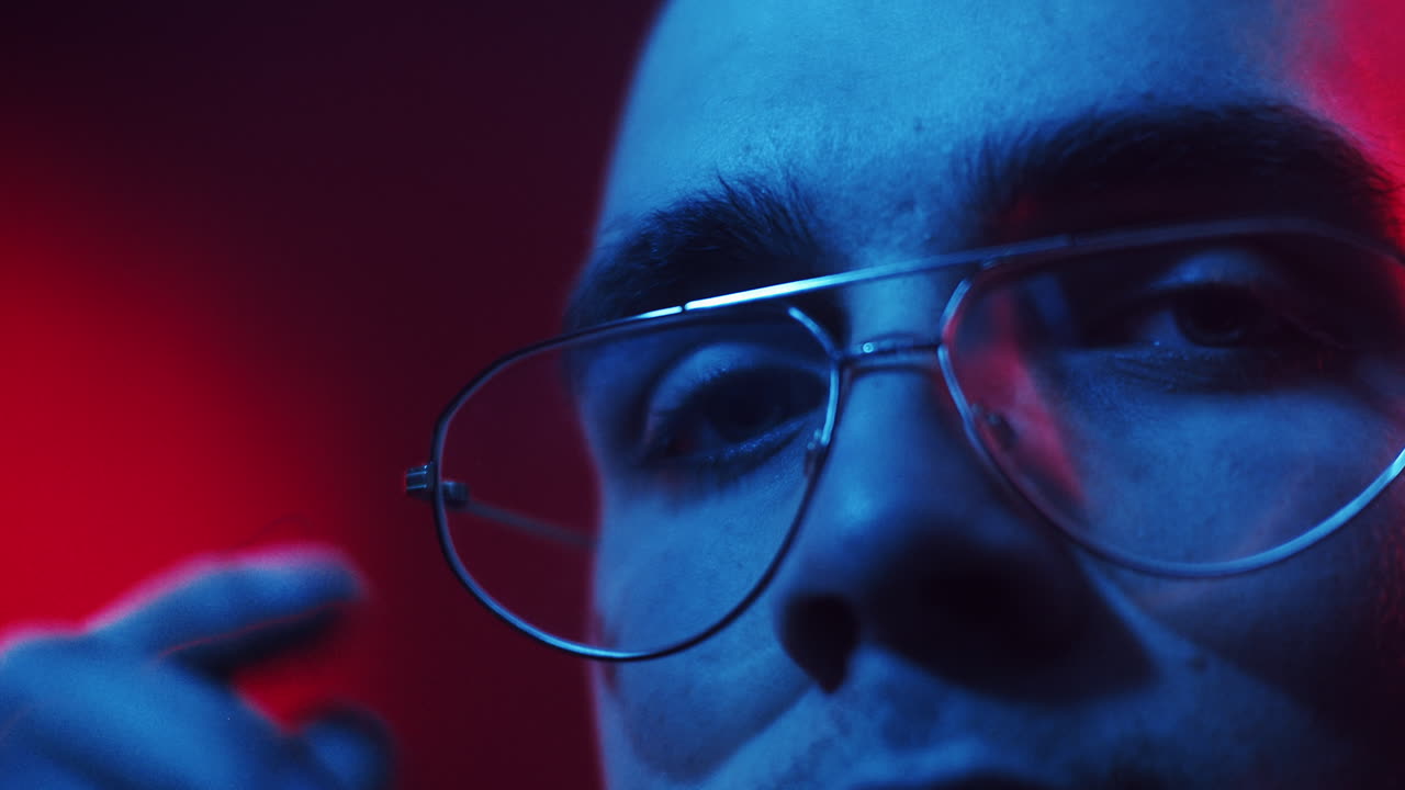Ritratto ravvicinato di un uomo con gli occhiali con vivace illuminazione al neon
