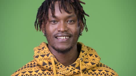 young happy african man against green background