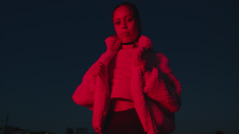 portrait beautiful woman posing in city at night with urban style looking confident rebellious female in red light