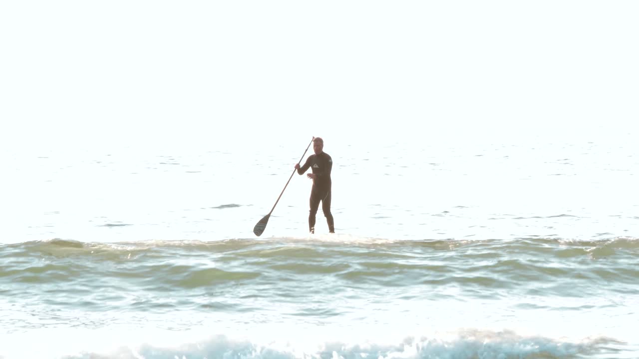 un surfista de remo en tofino bc al atardecer