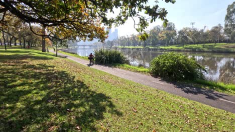 cyclist rides along scenic river path