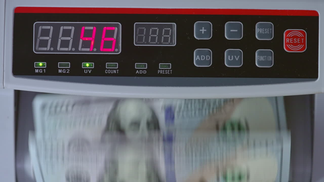 Control panel of cash counting machine. US dollars being counted in the device. Close up.