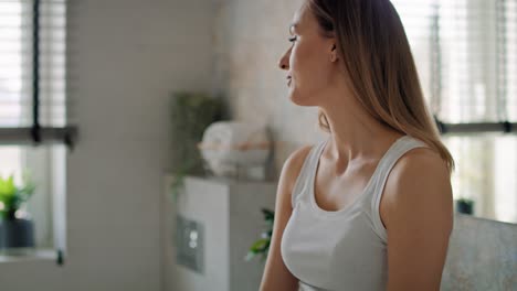 young caucasian woman in domestic bathroom looking at pregnancy test and feeling broken.