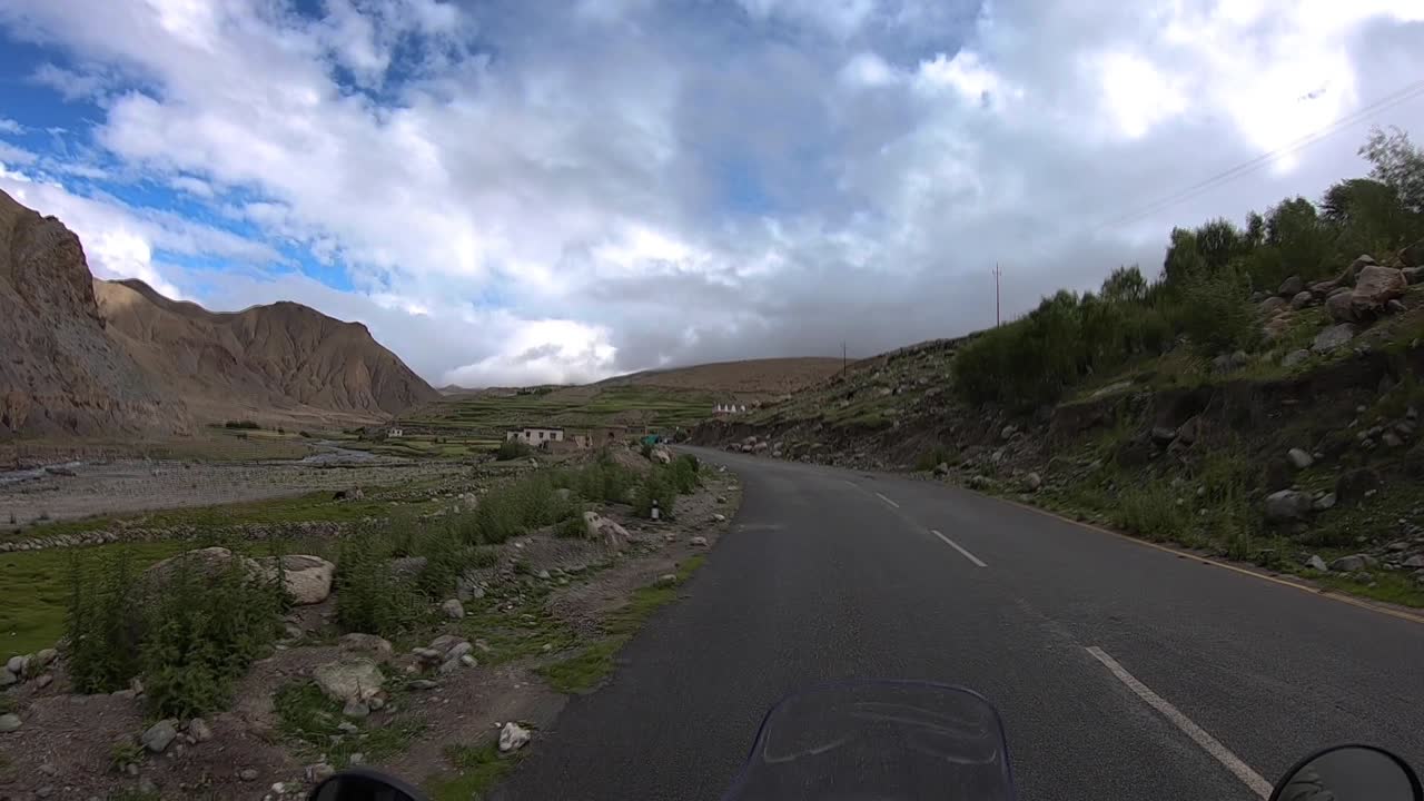작은 먼 마을을 향한 외의 사막 산길에서 혼자 운전하는 자전거 운전자의 시야에서 아름다운 광각 클립