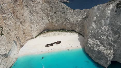 aerial shot over a shipwrecked boat on a paradisiac beach in the mediterranean island of zakynthos, greece