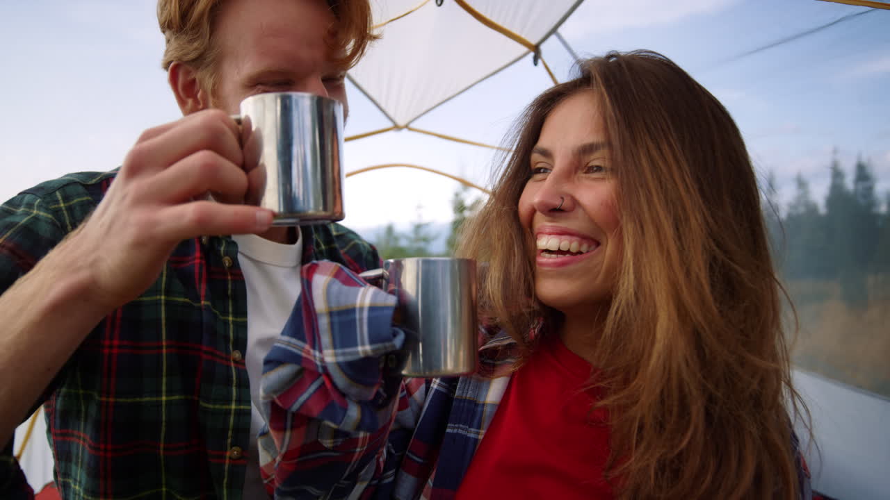 mujer y hombre felices haciendo sonar tazas con té en la tienda