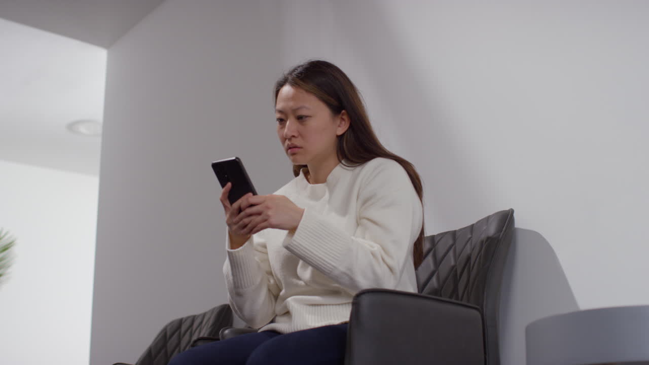 사무실 건물에서 스트레스를 받거나 불안한 여성이 인터넷이나 소셜 미디어 뉴스 메시지 또는 휴대 전화에 반응합니다.