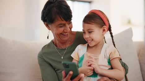 Grandmother,-funny-child-and-phone-on-sofa-in-home