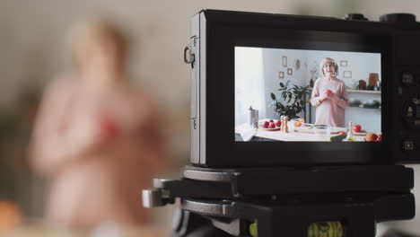 cámara digital grabando vlog culinario de una mujer mayor