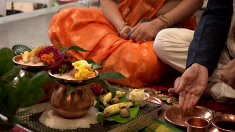 marido y mujer están viendo gruhpravesh pooja y tiraron agua en la mano