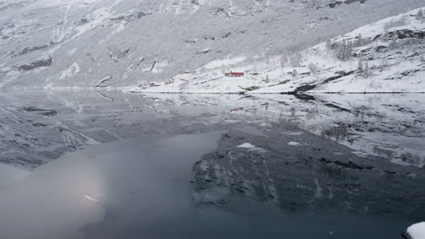 노르웨이의 geirangerfjord에서 보트를 타고 가는 장면, 겨울에는 피오르드의 조용한 아름다움과 주변의 눈 인 산을 강조합니다.