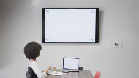 Biracial-casual-businesswoman-having-video-call-on-laptop-and-monitor-with-copy-space,-slow-motion