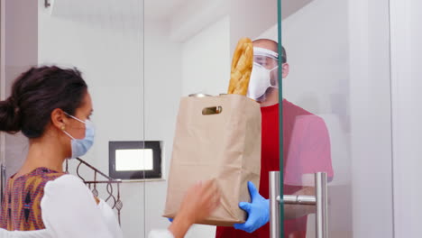 mensajero con máscara protectora entregando paquetes de alimentos