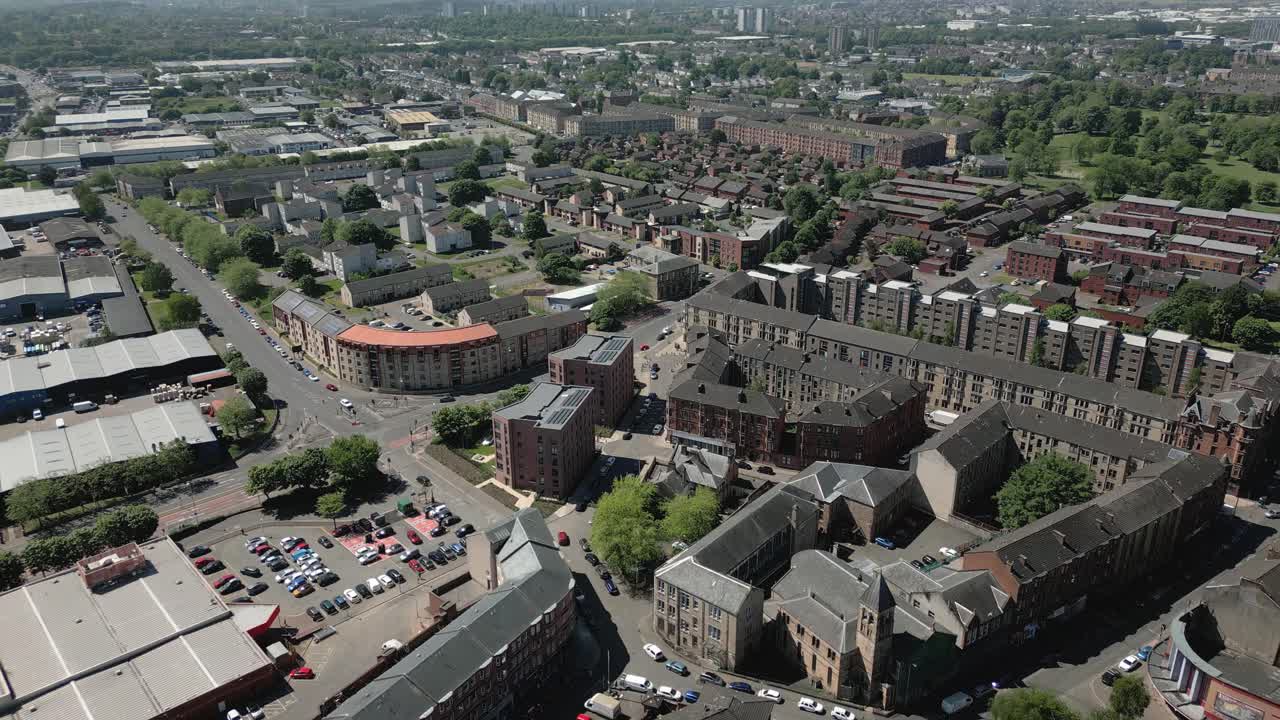 Low aerial flying over Govan district house blocks with parking and shops, Glasgow, Scotland, UK