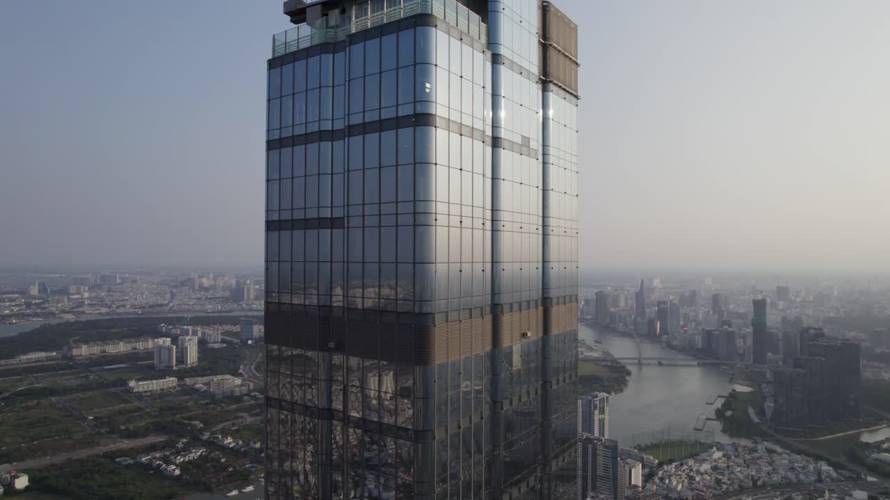 primer plano del edificio histórico 81 en la ciudad de ho chi minh, saigón, la torre más alta de vietnam durante la puesta de sol con reflejo de vidrio - video de avión no tripulado descendente