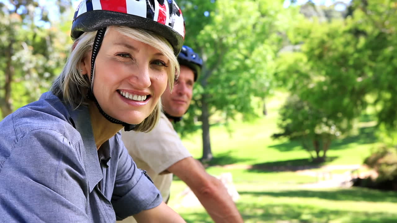una pareja feliz haciendo un paseo en bicicleta por el parque