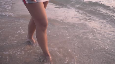 glückliche dame mit langen haaren geht langsamer über den strand
